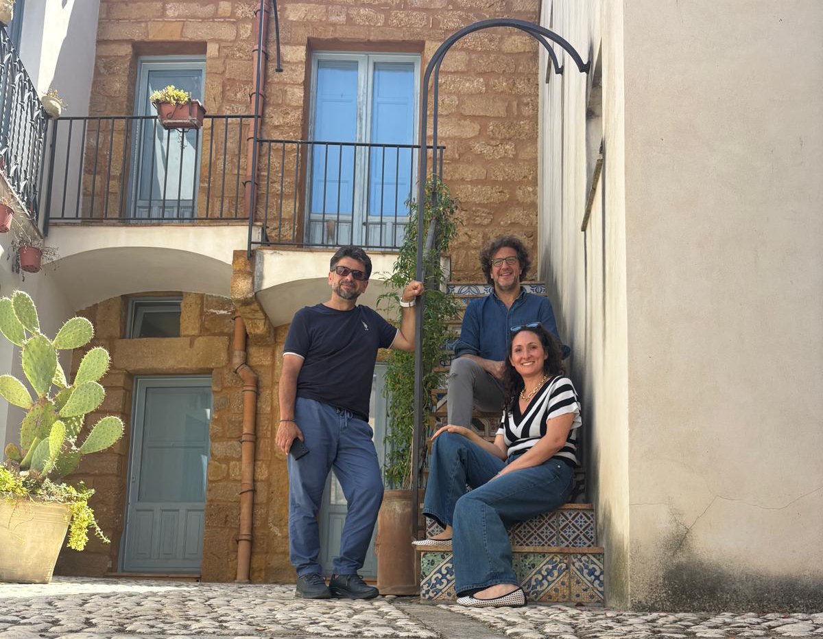 Il team Lapis insieme su una scalinata in un cortile in pietra